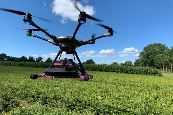 eine Drohne schwebt über einem Feld