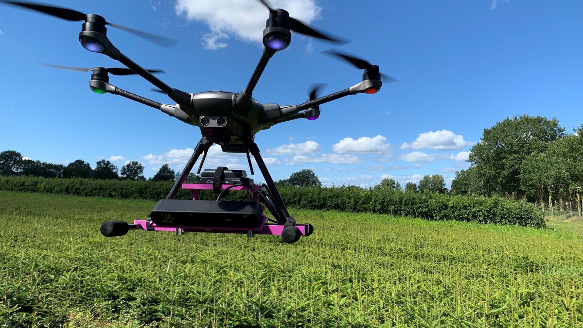 eine Drohne schwebt über einem Feld